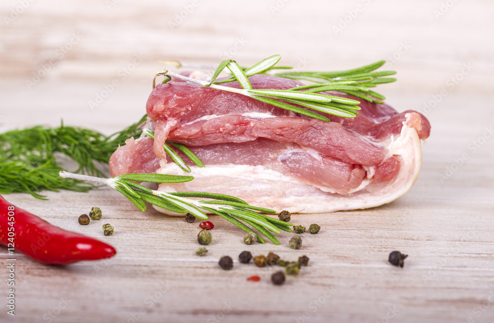 Fresh meat : raw pork meat with red chili pepper, dill and rosemary on wooden board Fresh meat : raw pork meat with red chili pepper, dill and rosemary on wooden board