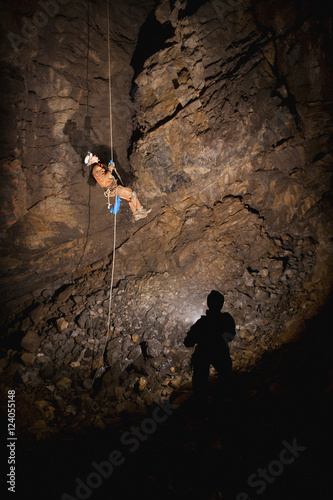 Male Athlete Ascending A Rope To Exit A Cave; Fernie, British Columbia, Canada photo