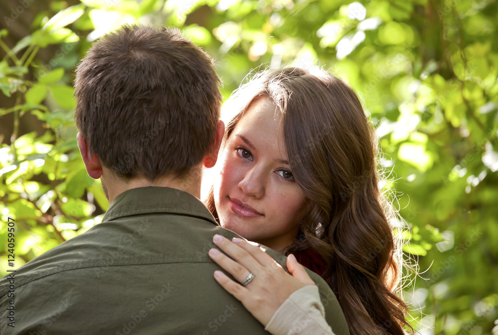 Newlywed Couple Embracing In A Park; Edmonton, Alberta, Canada Newlywed Couple Embracing In A Park; Edmonton, Alberta, Canada