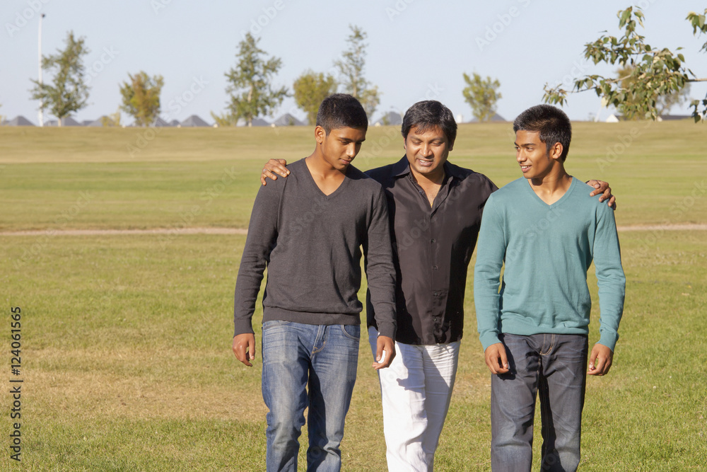 A Father And Two Sons Walking In A Park; Edmonton, Alberta, Canada A Father And Two Sons Walking In A Park; Edmonton, Alberta, Canada