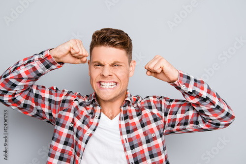 Portrait of depressed angry young man showing fists