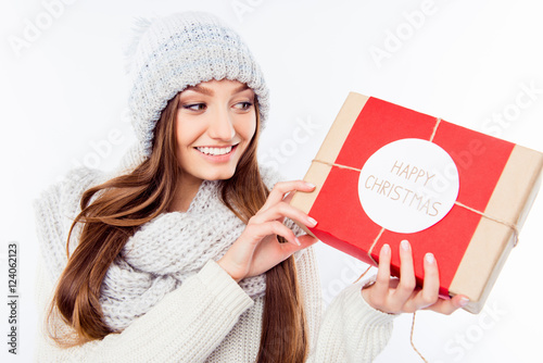 Cheerful woman  in warm hat and scarf holding package and congra photo