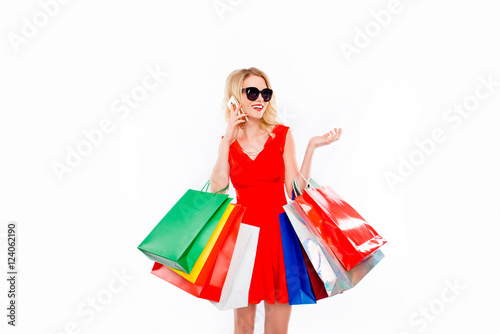 Young woman shopaholic with color paperbags talking on phone