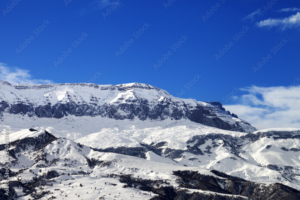 Snowy mountains and blue sky at nice sun winter day