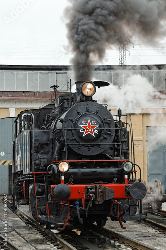 Old steam soviet locomotive. Low key photo. Vintage style. Red star and lettering USSR.