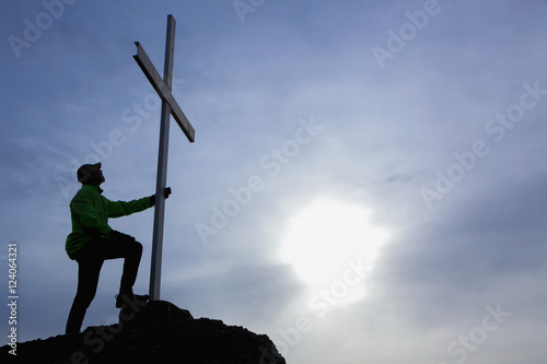 A Man Looks Up At Cross Located At The Top Of Mt. Tzouhalem In The Cowichan Valley; British Columbia, Canada