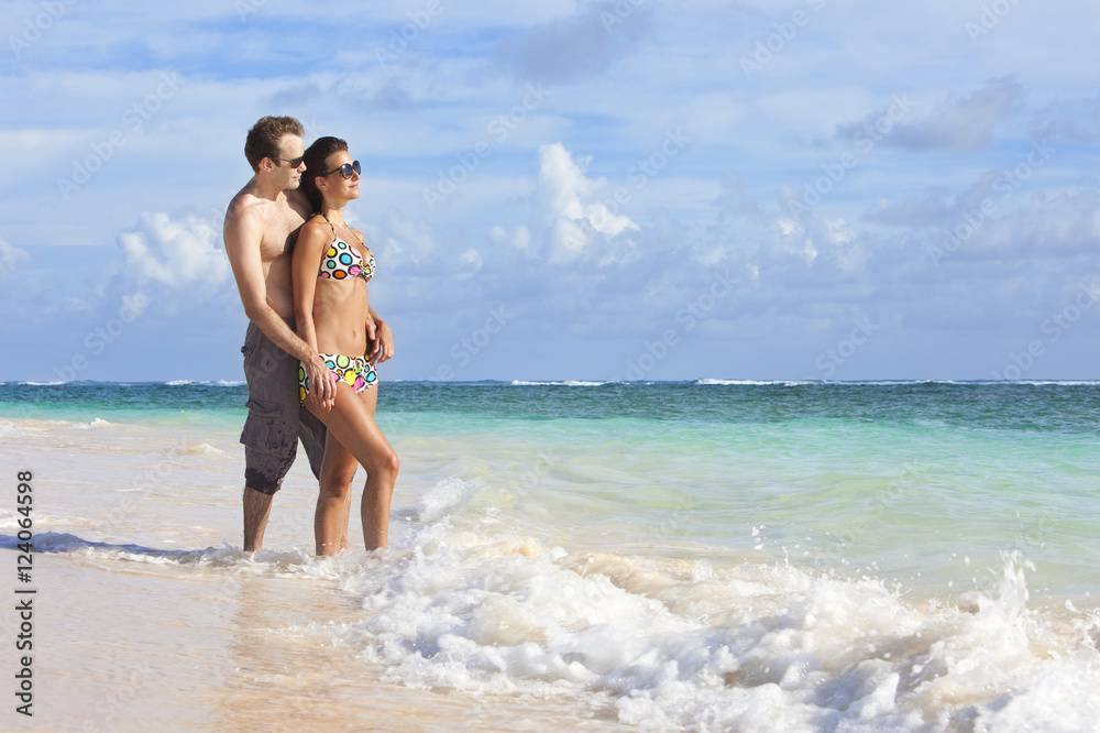 A Couple Wearing Swimsuits Stand In The Ocean Holding Hands; Punta Cana, La Altagracia, Dominican Republic A Couple Wearing Swimsuits Stand In The Ocean Holding Hands; Punta Cana, La Altagracia, Dominican Republic