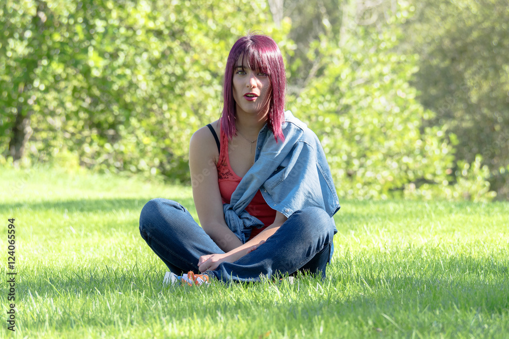 beautiful young woman sitting in the grass