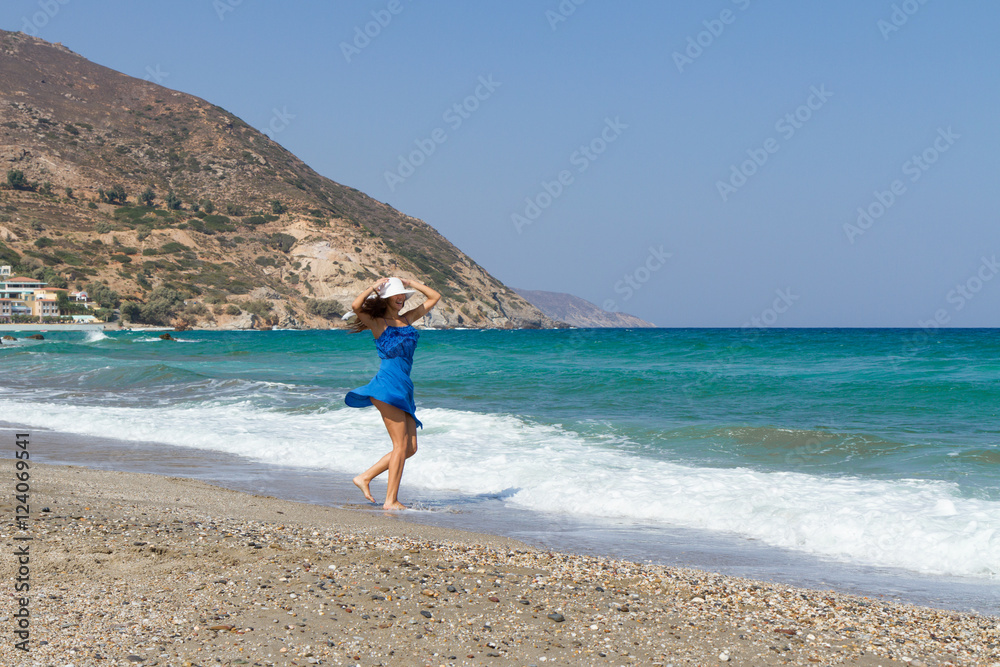 Beautiful stress free woman with blue dress at the beach