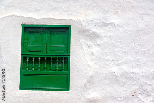 Green window on an old white colonial wall in Barichara, Colombia