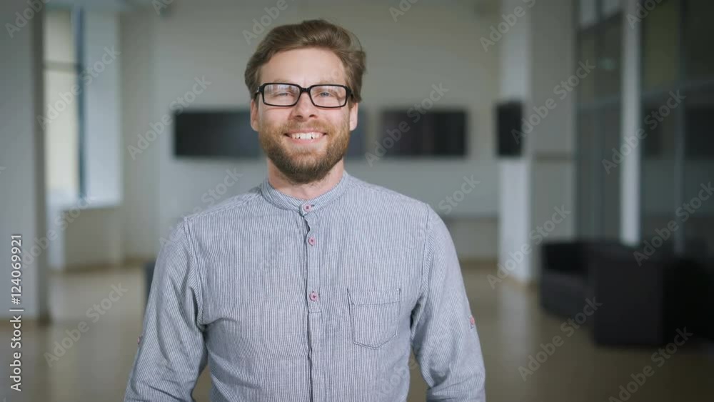 Casual businessman is standing in lobby and smiling Casual businessman is standing in lobby and smiling