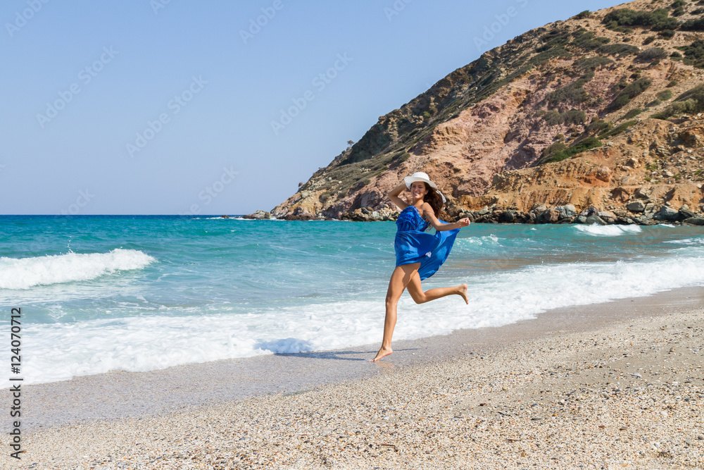 Beautiful stress free woman with blue dress at the beach