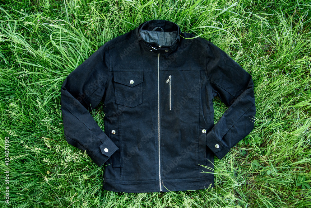 Black jeans jacket for man. Isolated on green grass background Black jeans jacket for man. Isolated on green grass background
