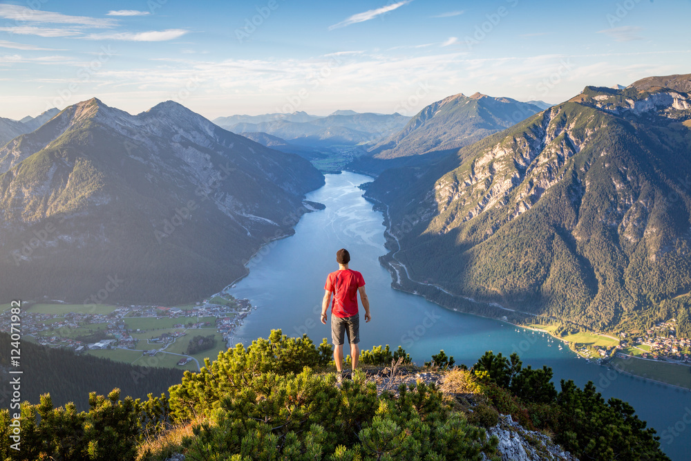 Mountaineer enjoying the view over lake Achensee in summer, Austria Tyrol - obrazy, fototapety, plakaty 