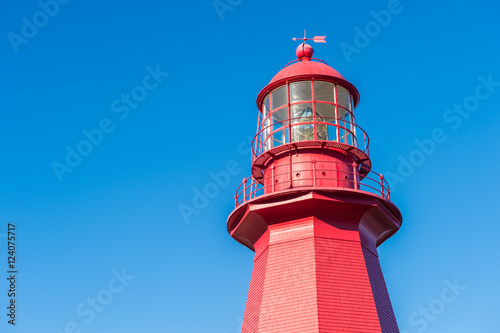 Top of a red lighthouse over blue sky in Gaspesie, Quebec (La Ma