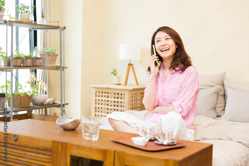 部屋で電話をする女性