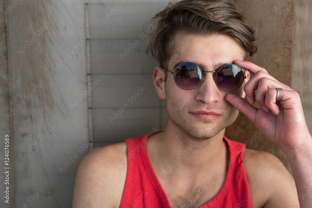 cool street skateboarder with sunglasses in front of iron wall. cool street skateboarder with sunglasses in front of iron wall.
