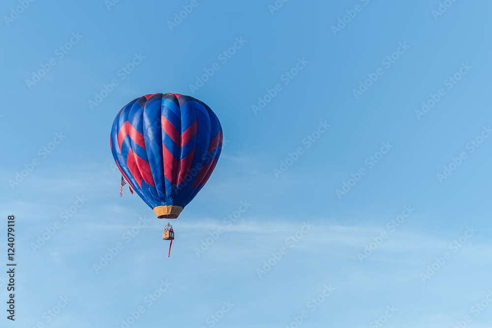 This is a photo of a beautiful hot air balloon slowly sailing through a calm blue sky. This is a photo of a beautiful hot air balloon slowly sailing through a calm blue sky.