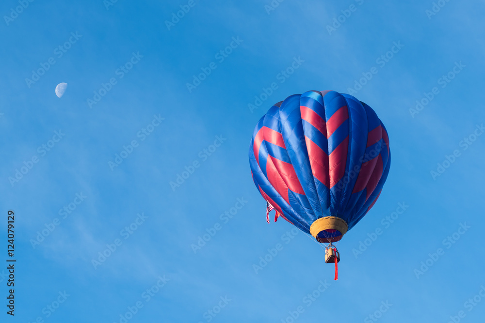 This is a photo of a beautiful hot air balloon slowly sailing through a calm blue sky. This is a photo of a beautiful hot air balloon slowly sailing through a calm blue sky.