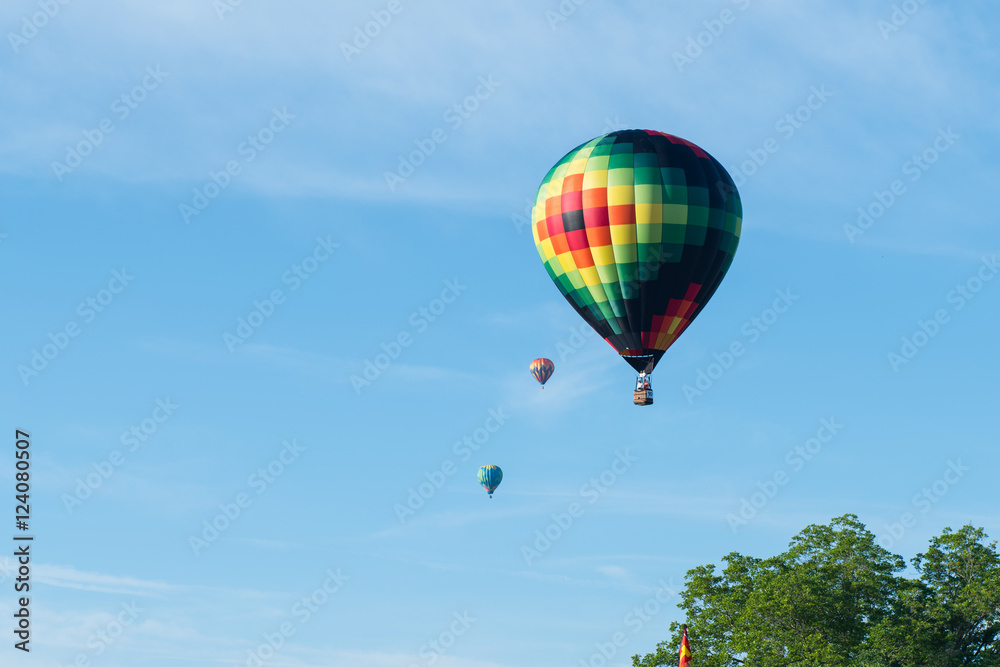 Fototapeta premium This is a photo of a beautiful hot air balloon slowly sailing through a calm blue sky.
