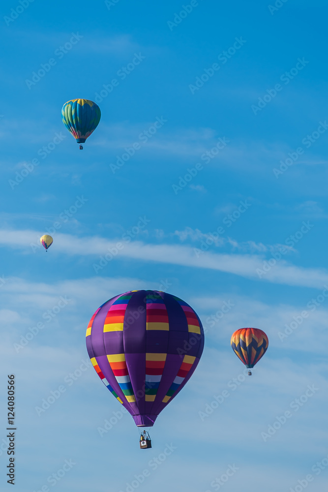 Fototapeta premium This is a photo of a beautiful hot air balloon slowly sailing through a calm blue sky.