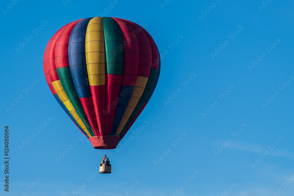 This is a photo of a beautiful hot air balloon slowly sailing through a calm blue sky. This is a photo of a beautiful hot air balloon slowly sailing through a calm blue sky.