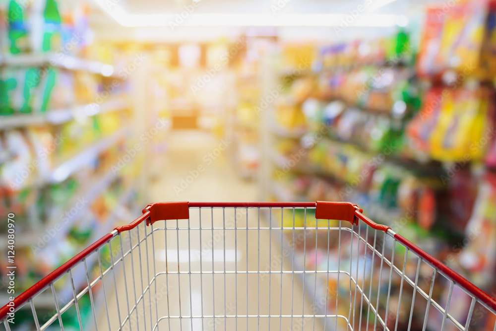 Shopping cart in Supermarket Aisle and Shelves in blur backgroun