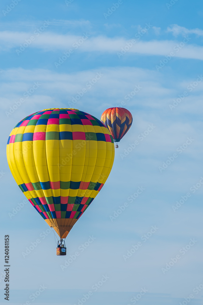 Fototapeta premium This is a photo of a beautiful hot air balloon slowly sailing through a calm blue sky.