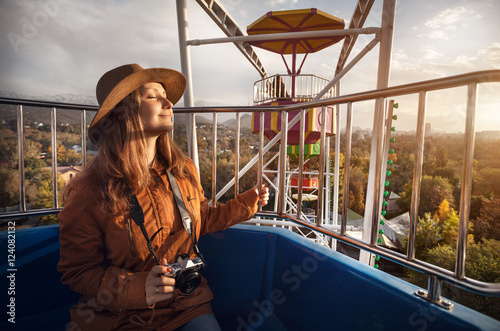 Woman with camera ride Ferris wheel