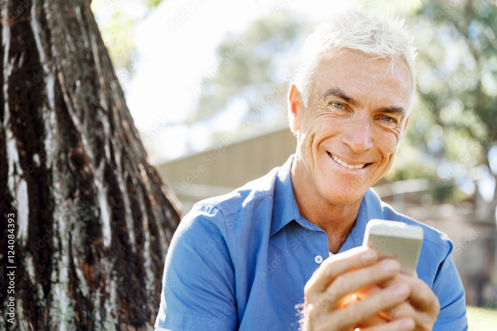 LoMature man outdoors using mobile phone LoMature man outdoors using mobile phone