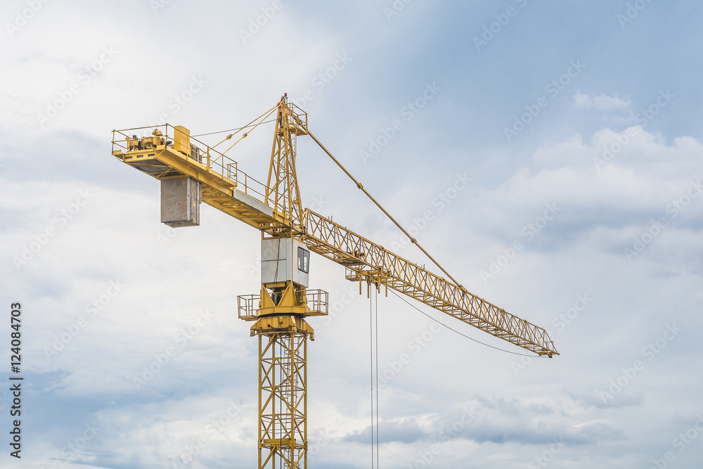 Yellow iron crane standing against the blue cloudy sky. Yellow iron crane standing against the blue cloudy sky.