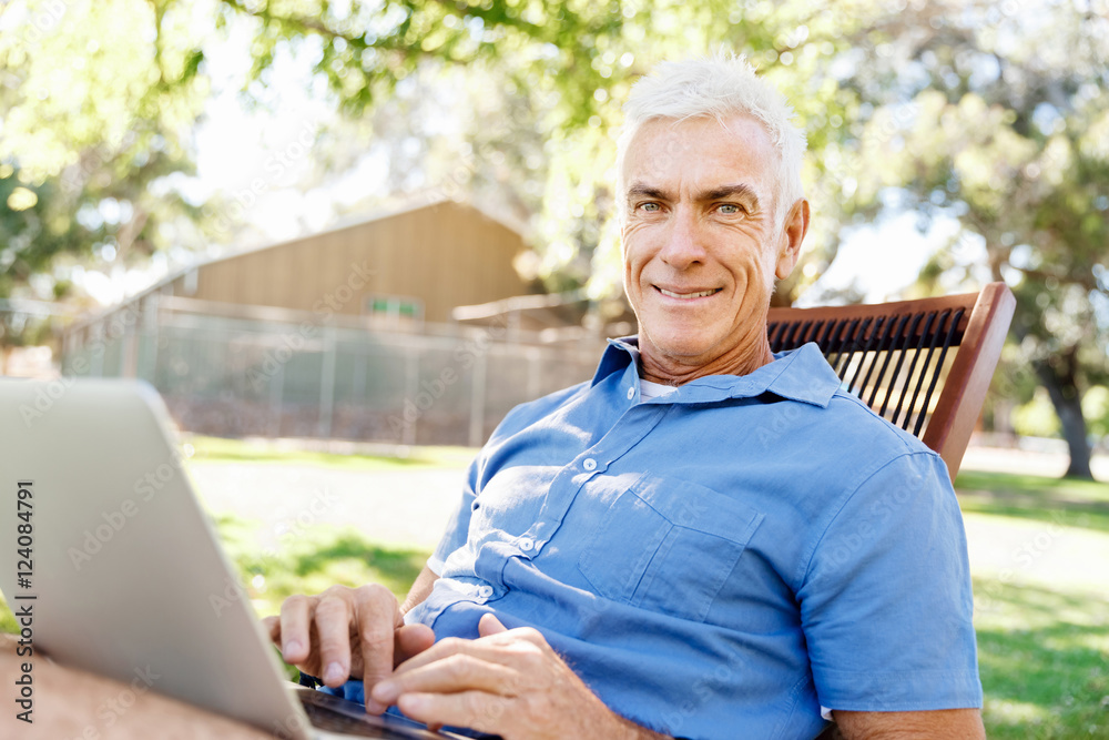 Senior man with notebook sitting in the park Senior man with notebook sitting in the park