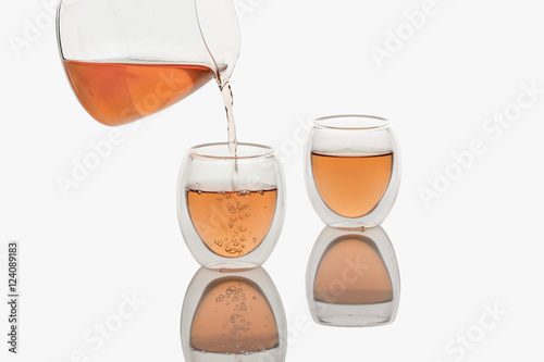 Tea pouring into Double-wall Glass Tea Cup, isolated in white photo