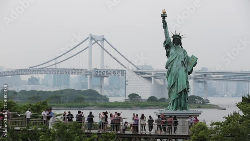 Wide establishing Statue of Liberty replica at Odaiba, overlooking the Rainbow Bridge in Tokyo Bay. photo