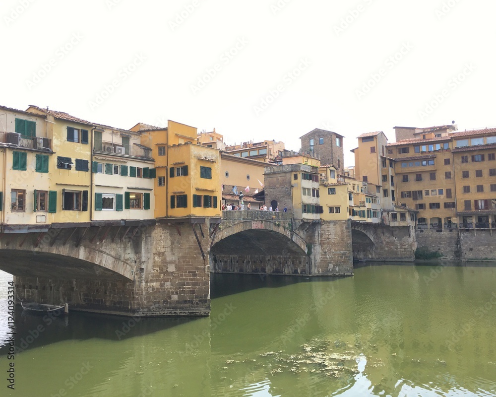 LORENCE, ITALY - JULY 25, 2016 : view of the famous Ponte  Vecchio in Florence during summer with boats on the river. 