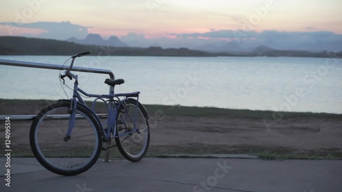 Bike on a beach, handheld shot bicycle locked to a railing at Imboassica lake in Rio, Brazil,  photo