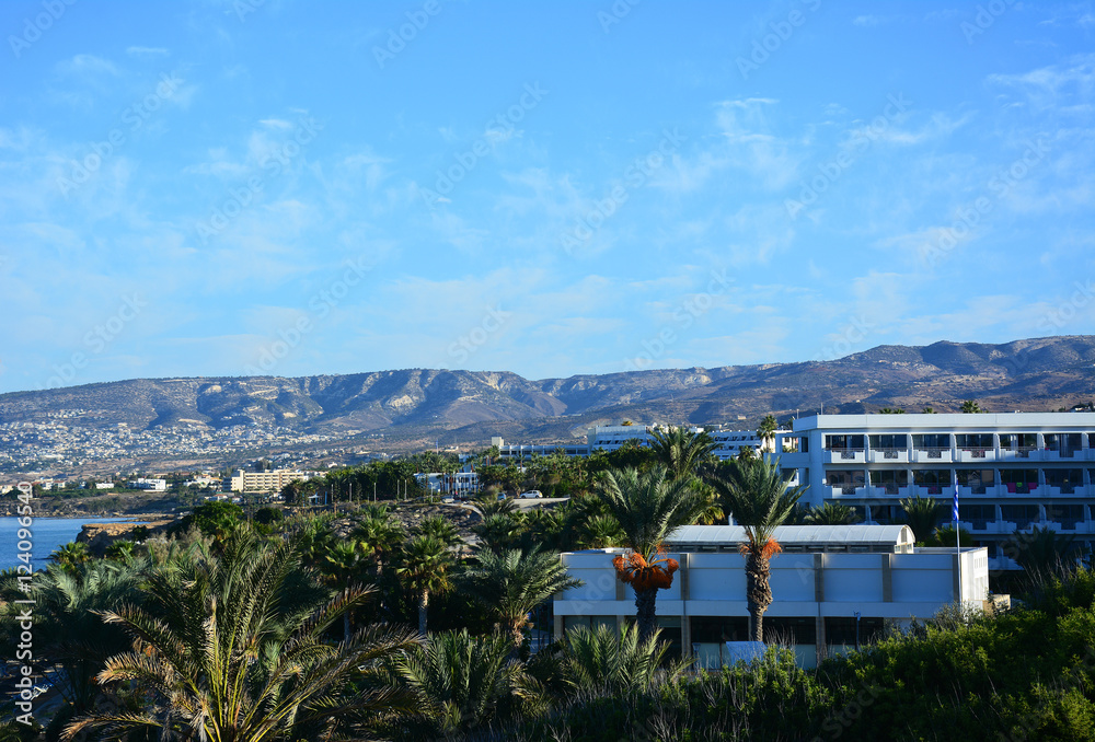 Tropical landscape: the sea, palm trees, mountains, blue sky