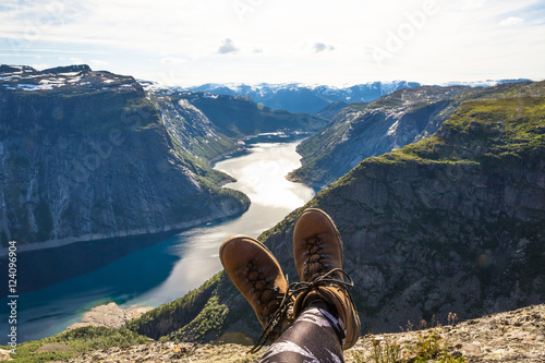 Happy hiker relax on Trolltunga. Mane enjoy beautiful lake and good weather in Norway. © lkoimages