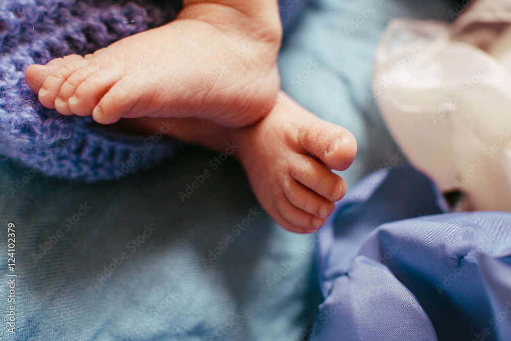 Tiny child's feet hang over the blue bed Stock Photo Adobe Stock