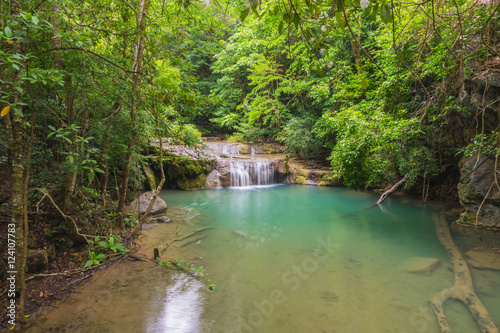 Emerald waterfall in forest landscape.