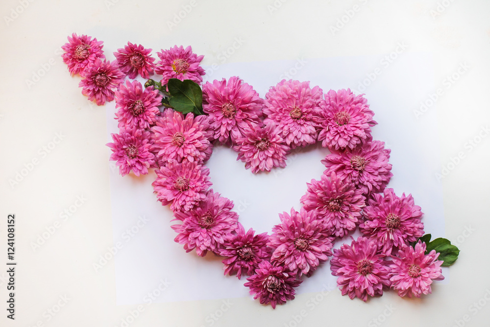 Creative floral background. Closeup of a heart of roses and invitation card with space for text. Flower invitation. Season greetings. Top view, flat layout, top view. Creative floral background. Closeup of a heart of roses and invitation card with space for text. Flower invitation. Season greetings. Top view, flat layout, top view.