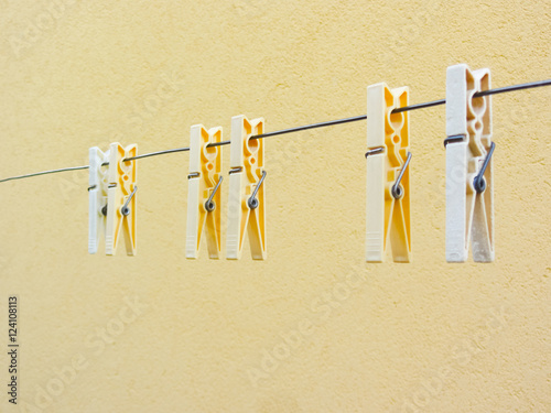 Plastic clothespins on yellow background