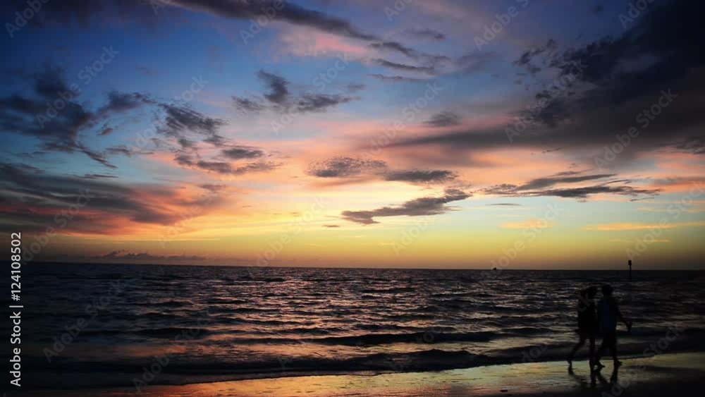 Tranquil beach scenic, Florida beauty sunset, wide seascape shot with people walking on beach. Tranquil beach scenic, Florida beauty sunset, wide seascape shot with people walking on beach.