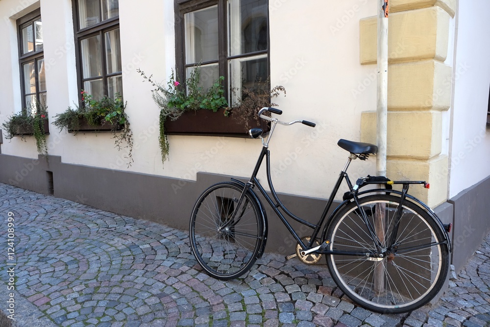 Parked bicycle in narrow street in the old town of Riga, vintage style.
