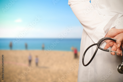 The doctor put his hands with stethoscope behind his back on a b