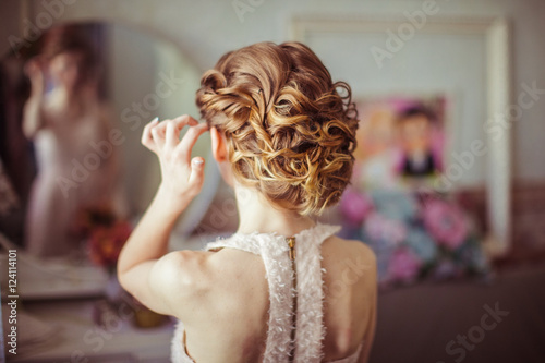 Look from behind at bride's curly hair made up
