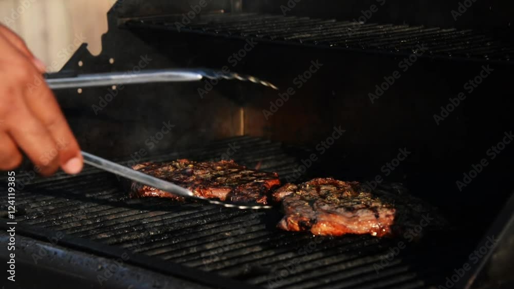 Grilling pork chops, using tongs at BBQ, From grill to plate. Grilling pork chops, using tongs at BBQ, From grill to plate.