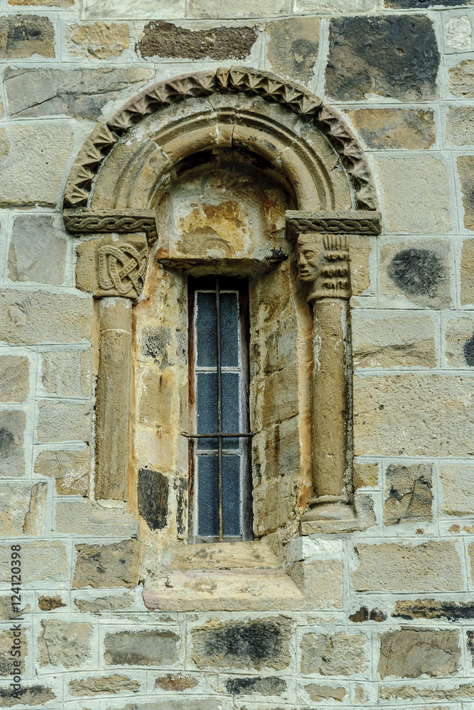 sight of a window of the Romanesque collegiate church of San Salvador in Cantamuda in Palencia, Castile and León, Spain