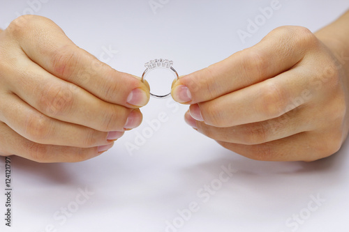 Hands holding a ring on a white background