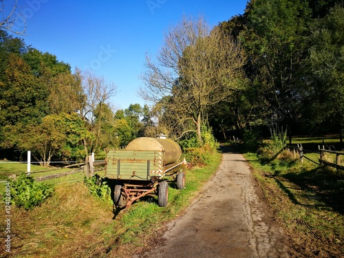 Alter Anhänger mit Wassertank an einem alten Weg für die Landwirtschaft bei blauem Himmel im Sonnenschein zwischen Oerlinghausen und Asemissen bei Bielefeld im Teutoburger Wald in Ostwestfalen-Lippe photo